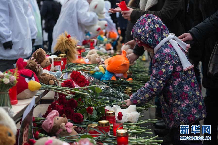 3月27日，在俄罗斯首都莫斯科，一名儿童摆放鲜花悼念克麦罗沃火灾遇难者。
